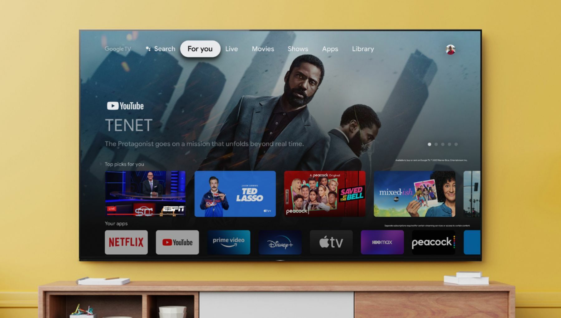 Sony Bravia 65-inch X90J 4K TV hanging on yellow wall.