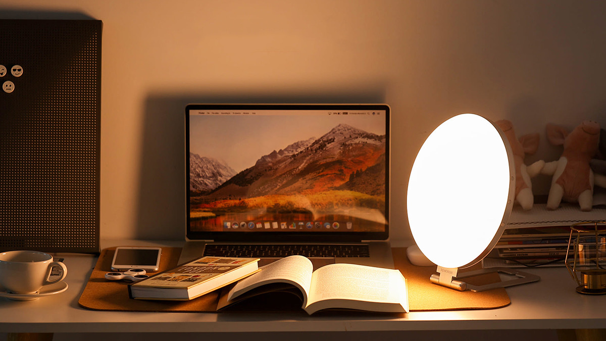 Warm-toned egg-shaped light shining over book on table