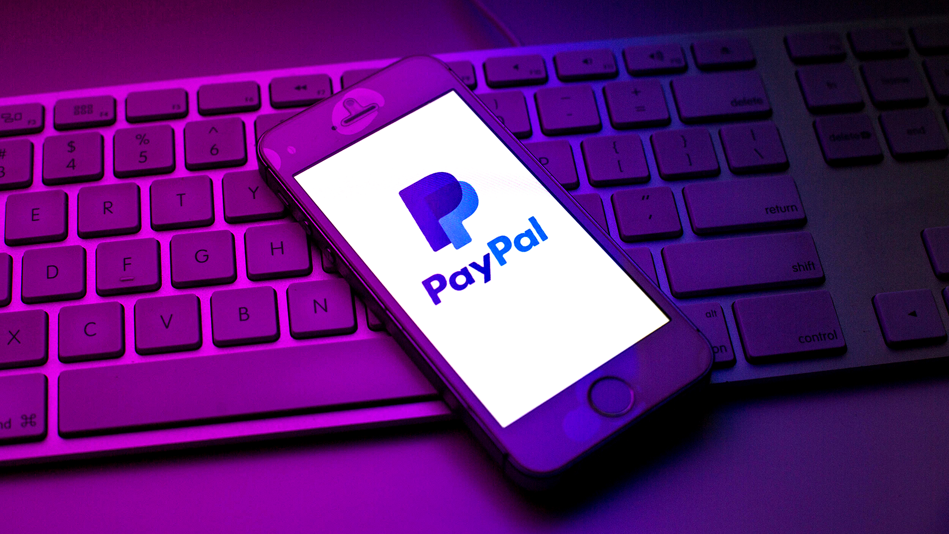 paypal logo on phone on top of keyboard