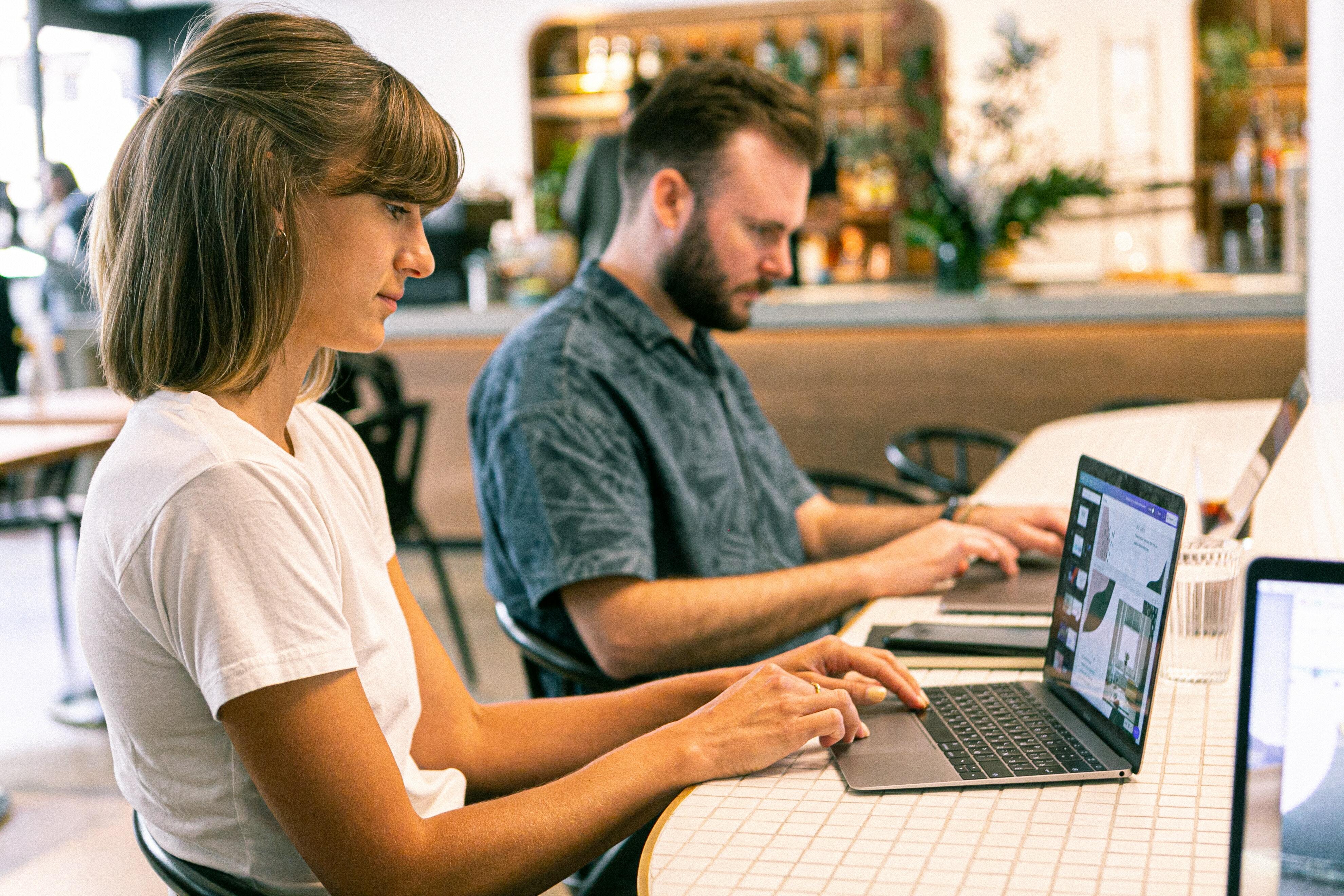 Two people working on laptops