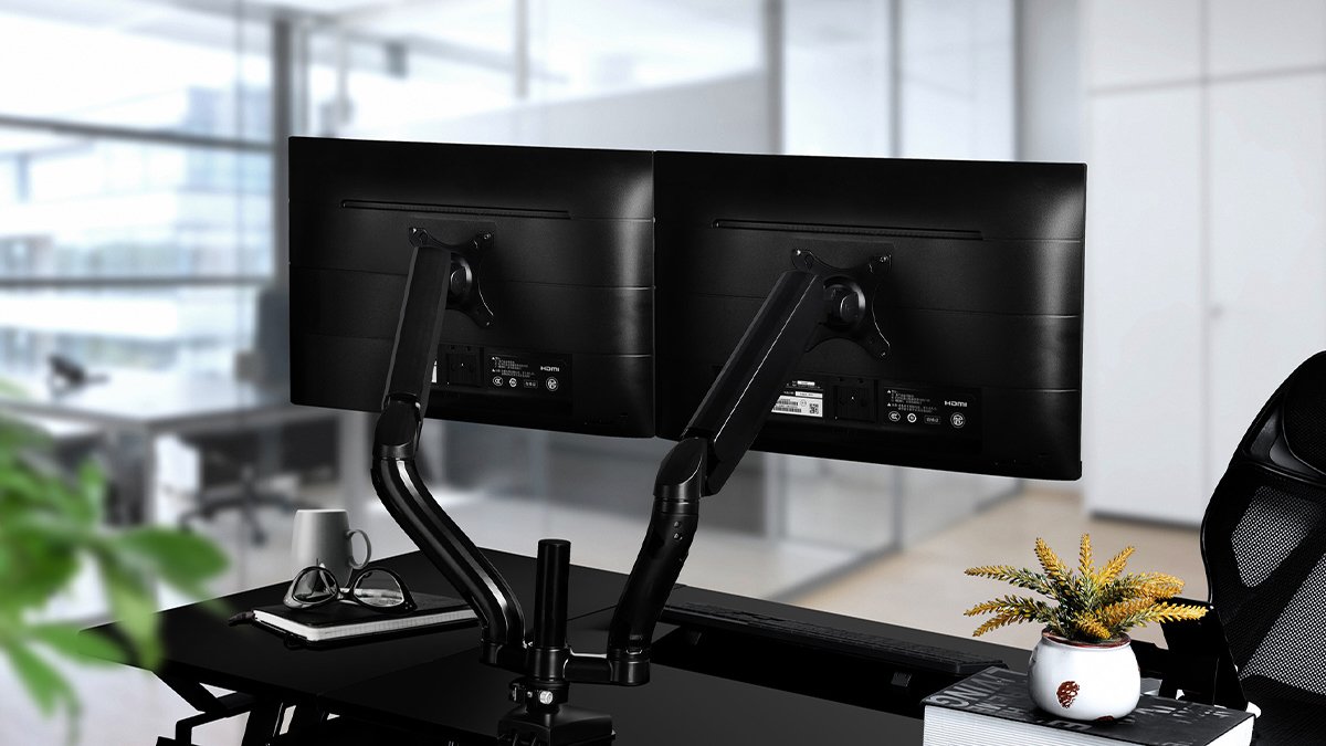 Desk with two black monitors on dual black arms