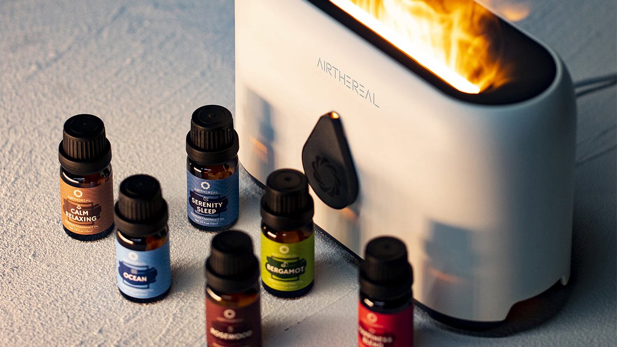 White aroma diffuser with six essential oil bottles beside it