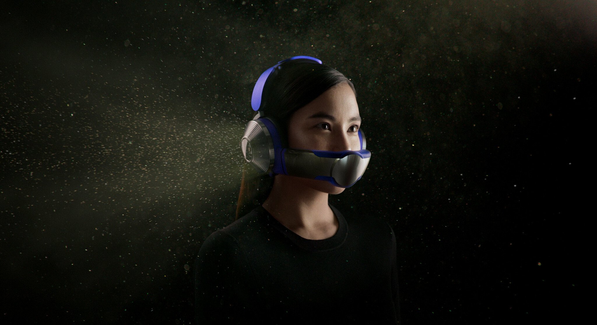 Woman wearing silver over ear headphones with a visor attached across the mouth and nose area.