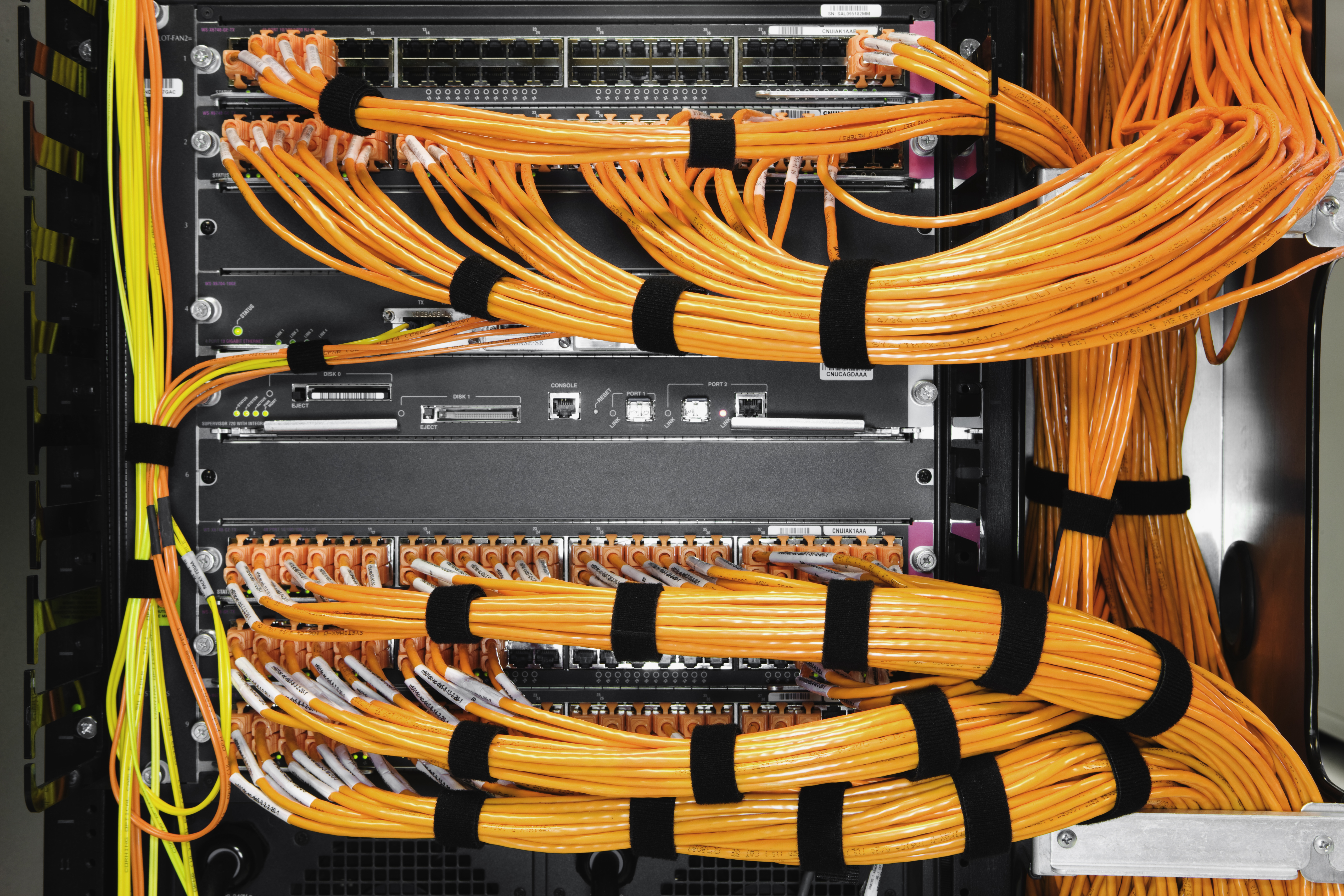 Many orange cables connected to a server box.