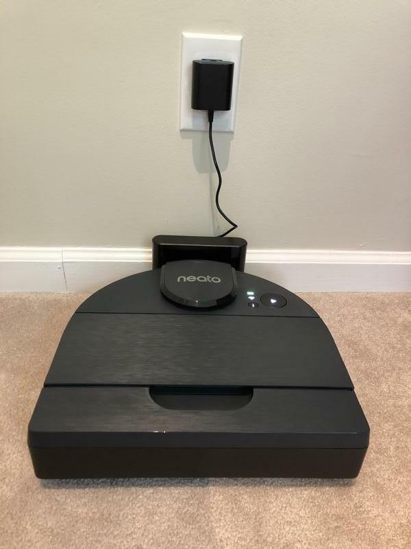 robot vacuum sitting on its dock on hardwood floor
