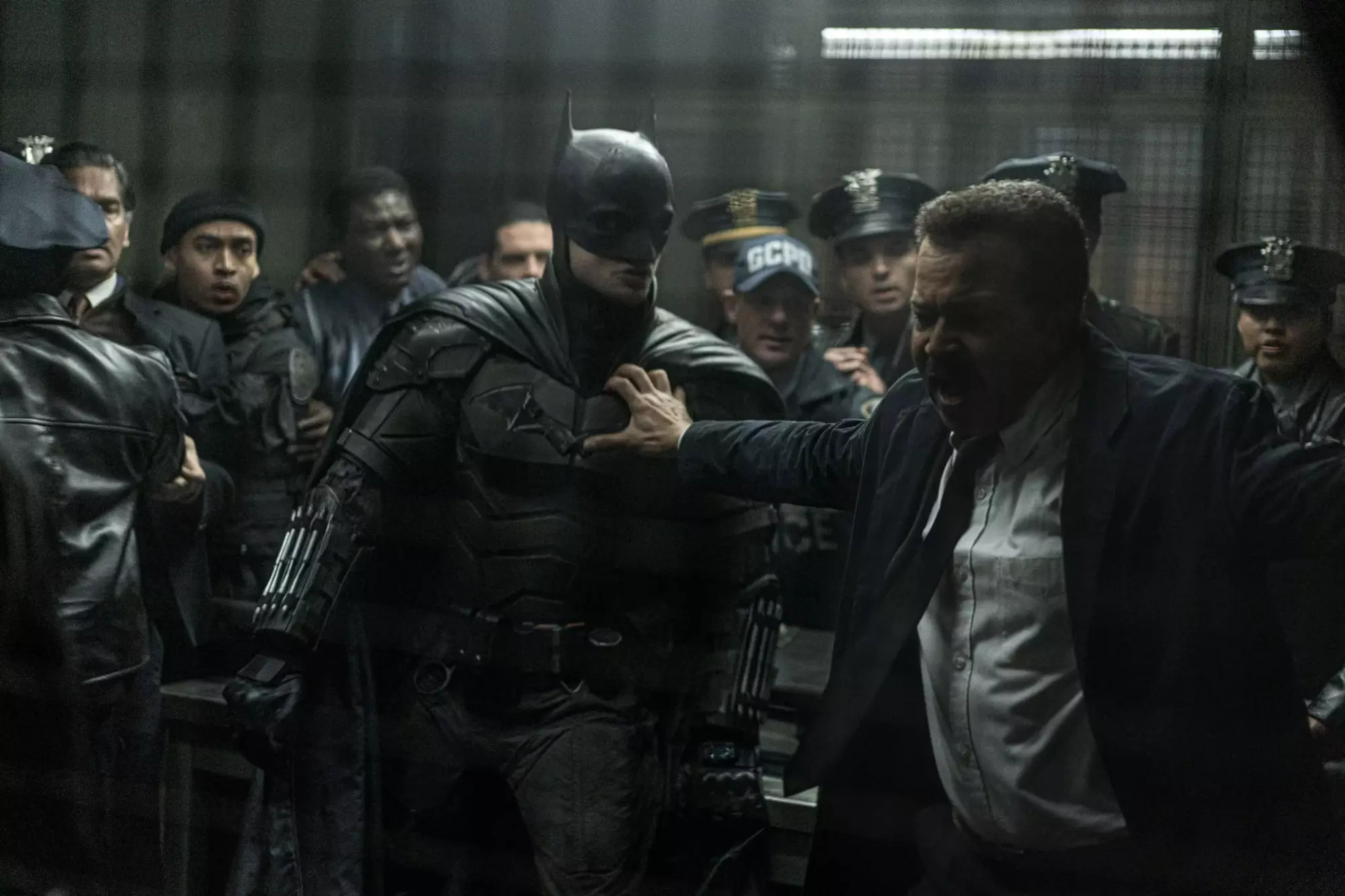 Jeffrey Wright as James Gordon holds back Robert Pattinson as The Batman