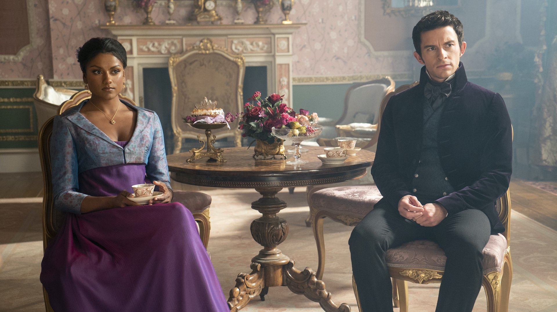 A man and woman in the Regency era sitting in a tea room; still from "Bridgerton."