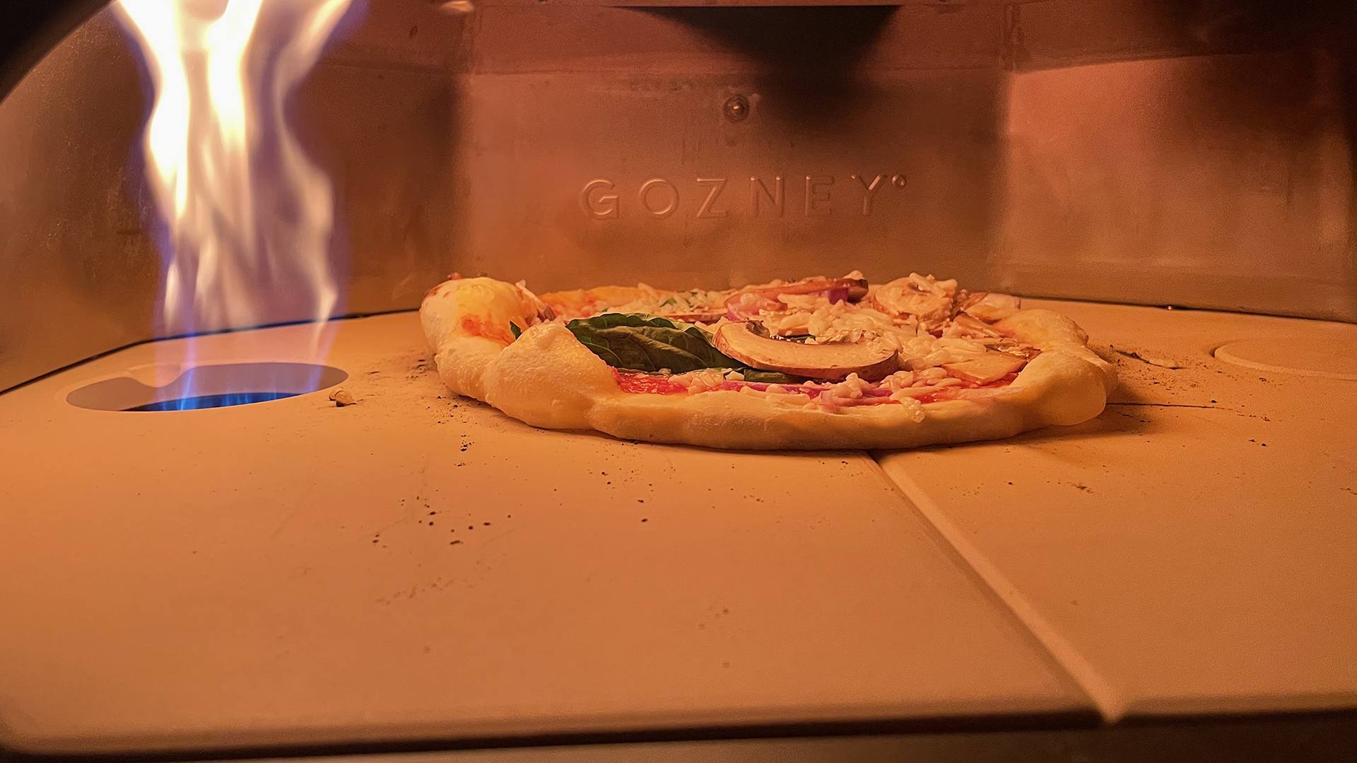 pizza inside gozney dome with gas flame