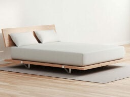 White mattress and pillows on wooden frame