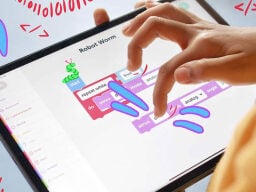 Finger using coding app on tablet screen