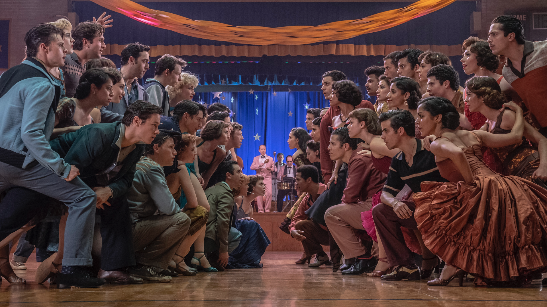 Two groups face each other on a dancefloor, one side in blue, one in red in "West Side Story."