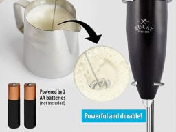 Silver jug of frothed milk with closeup of frother in it, next to black frother and picture of two batteries