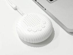 White circular device with speaker holes and buttons