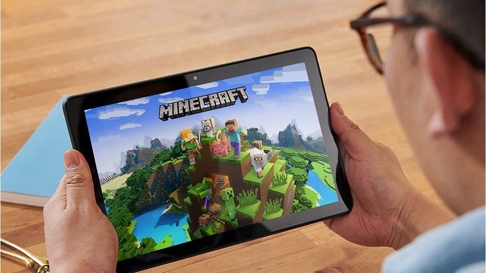 Hands holding Fire tablet with Minecraft open on screen