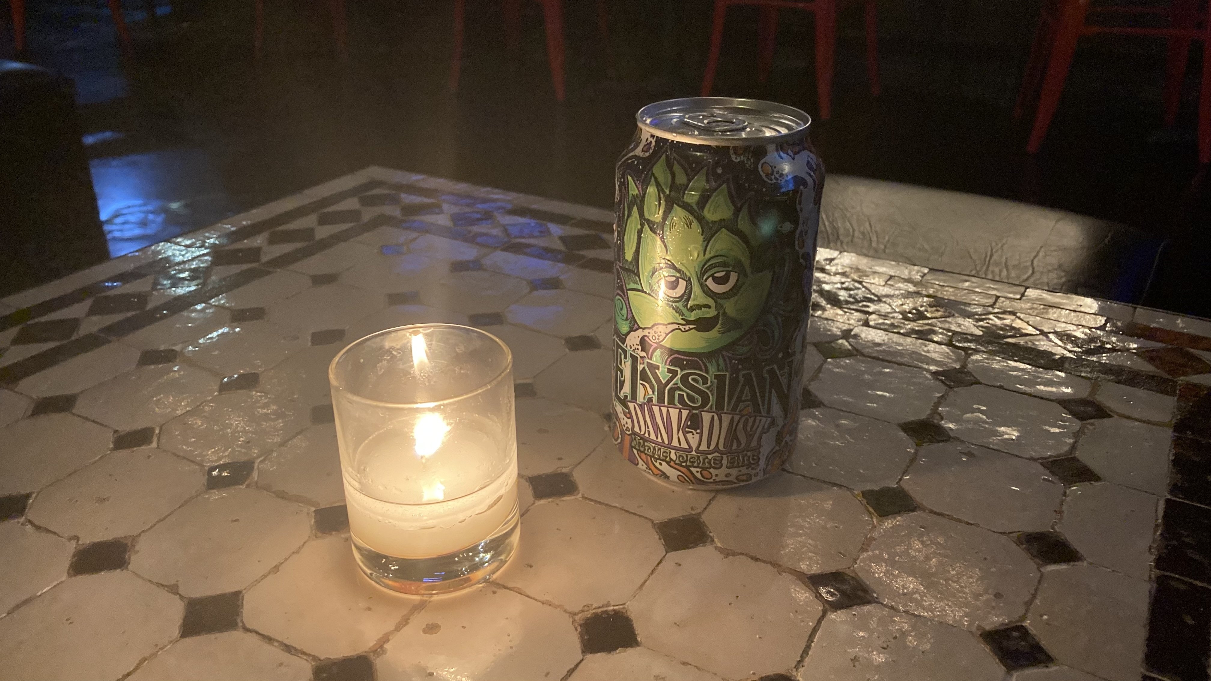 Dank Dust beer can next to candle at bar