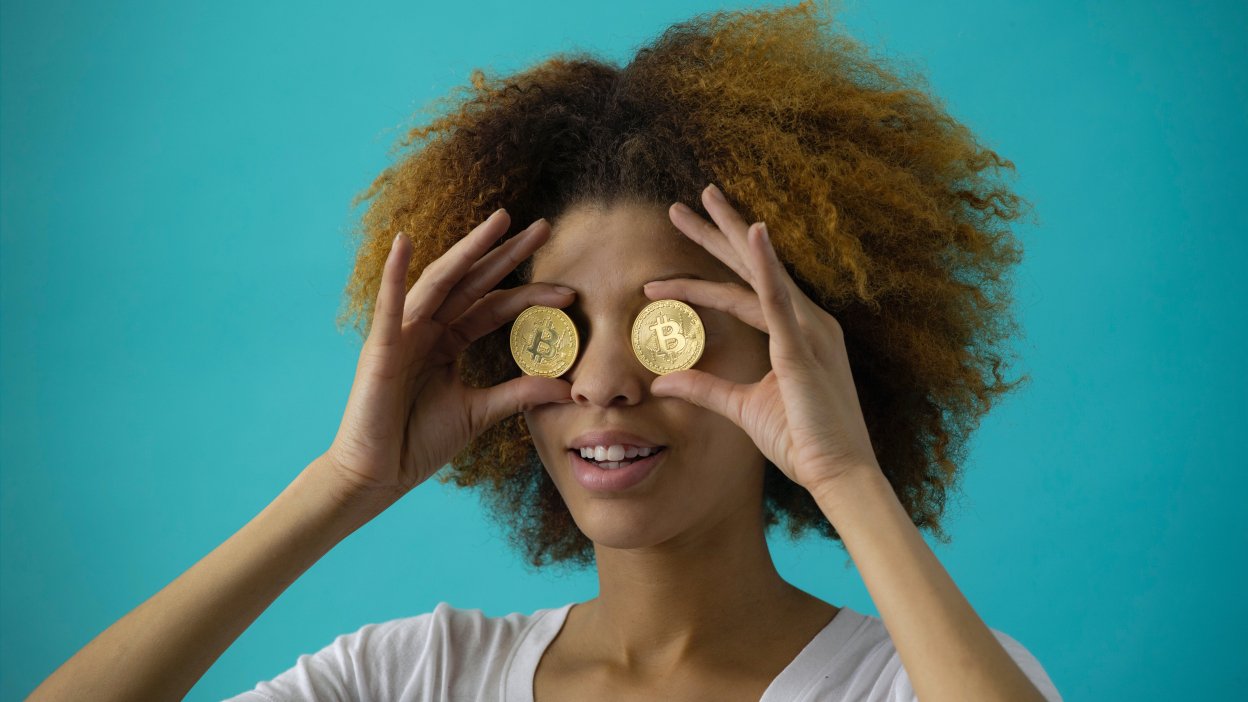 Person holding bitcoins over eyes