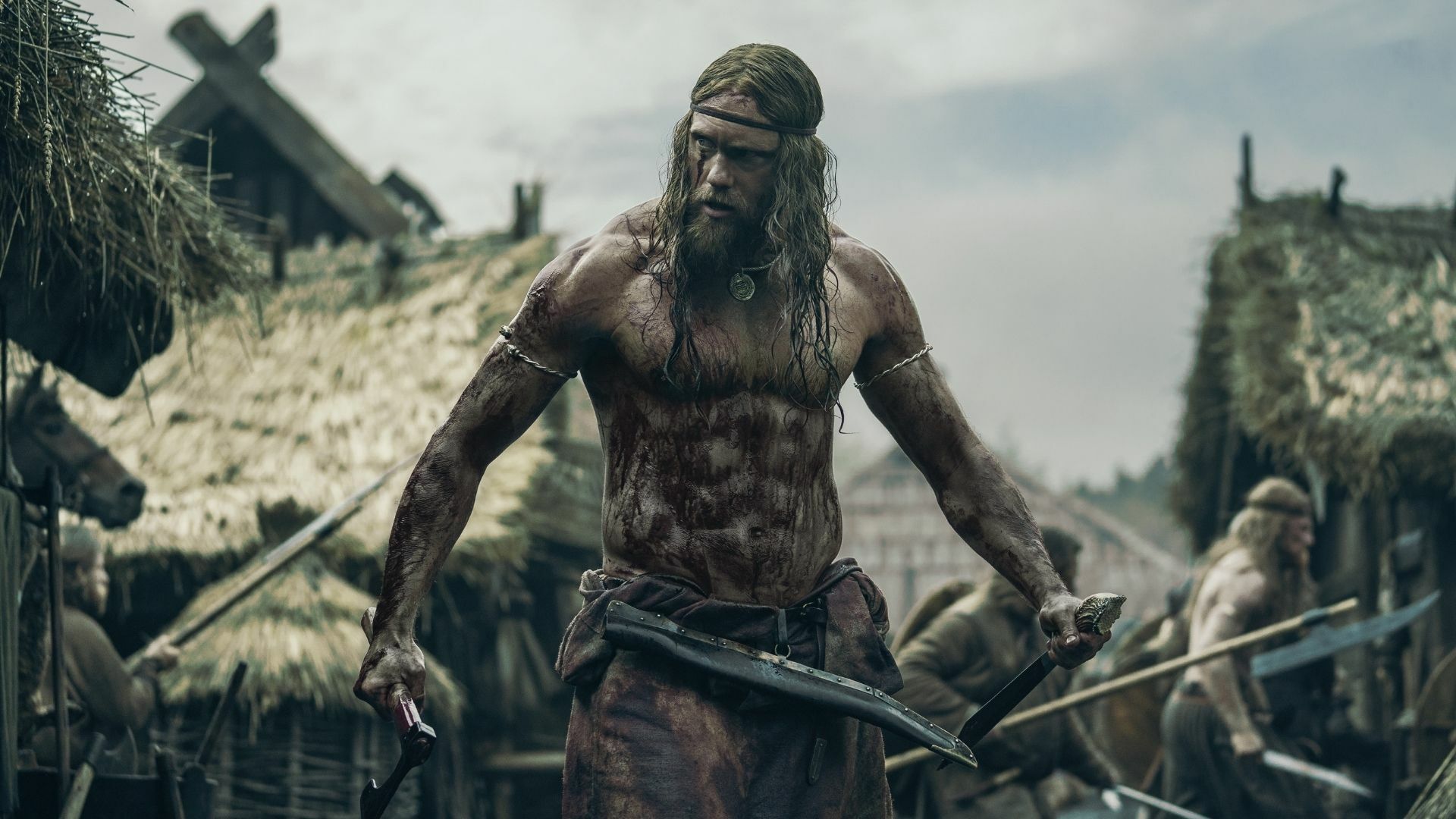 A viking flexes, shirtless and covered in mud and blood. 