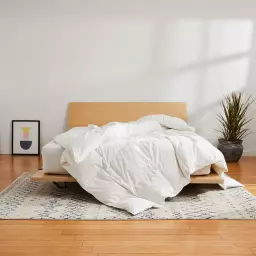 A cozy bed with fluffy white bedding on it
