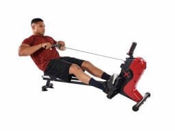 Person using red rowing machine and pulling handle back