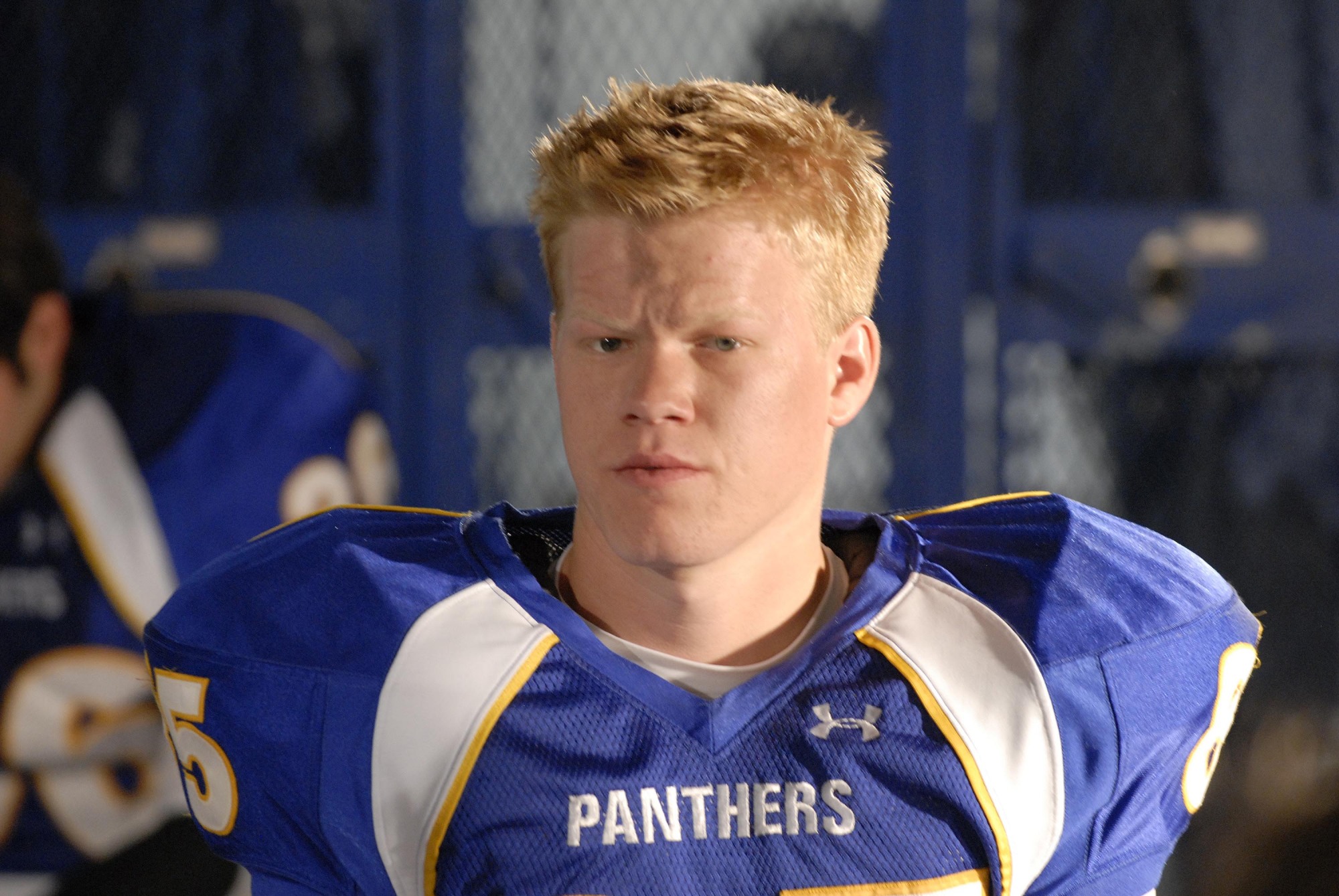 A teenage boy in a blue football jersey that says "PANTHERS."