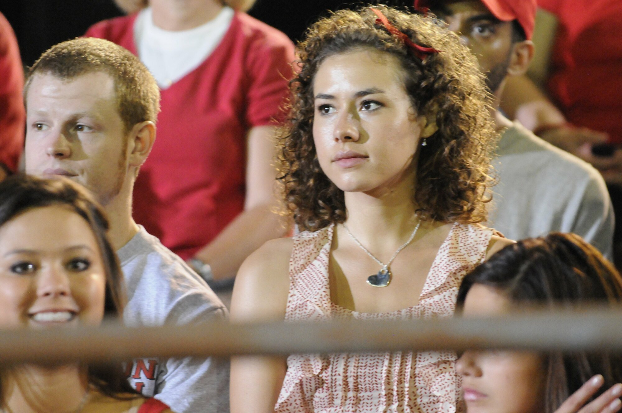 A teenage girl (Madison Burge as Becky Sproles on "FNL") sitting on bleachers surrounded by people.