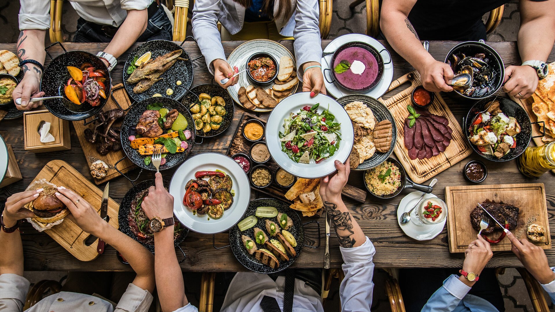 An overhead view of a table filled with plates of food.
