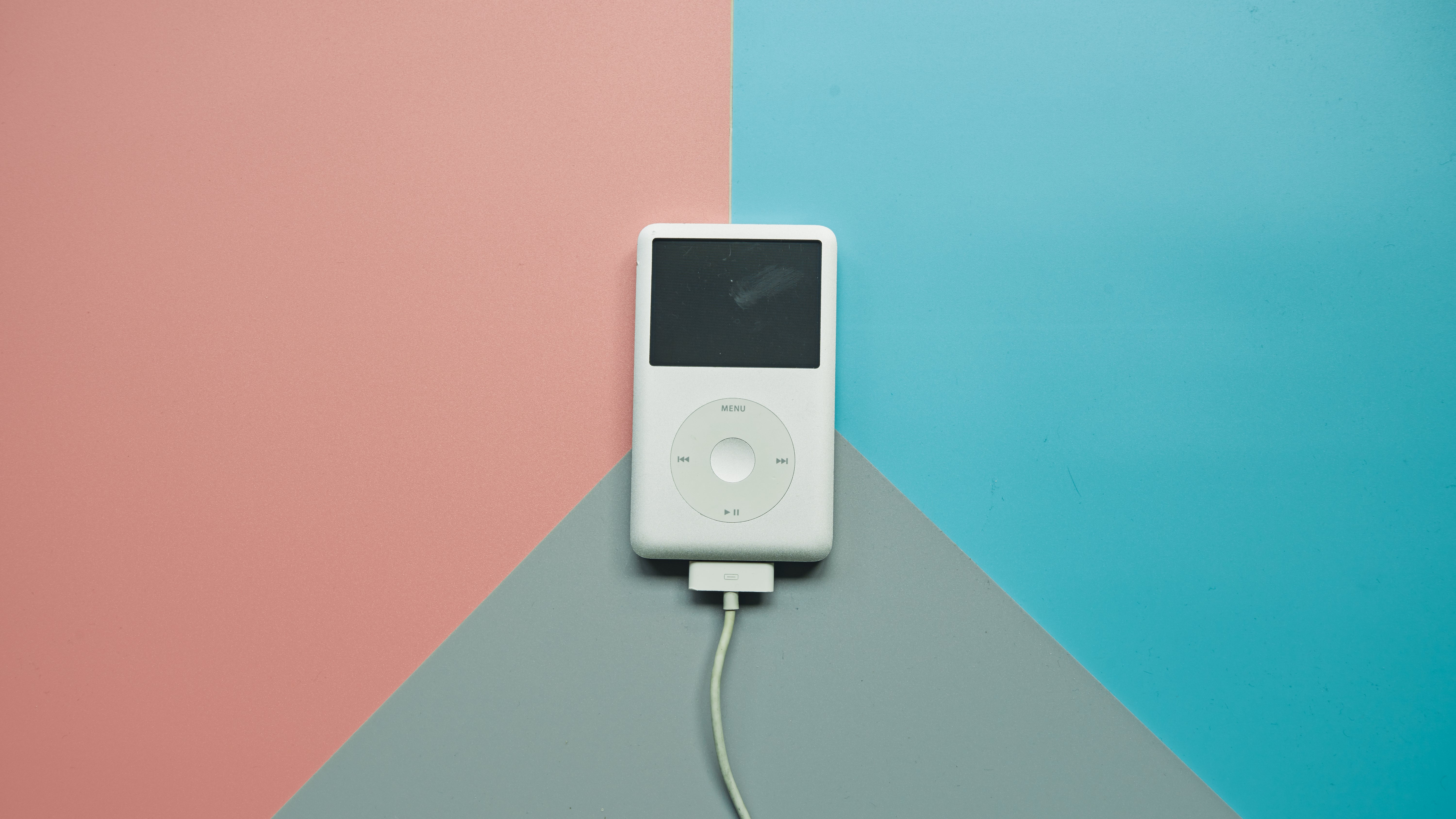Image of iPod classic against a pink and blue geometric background.