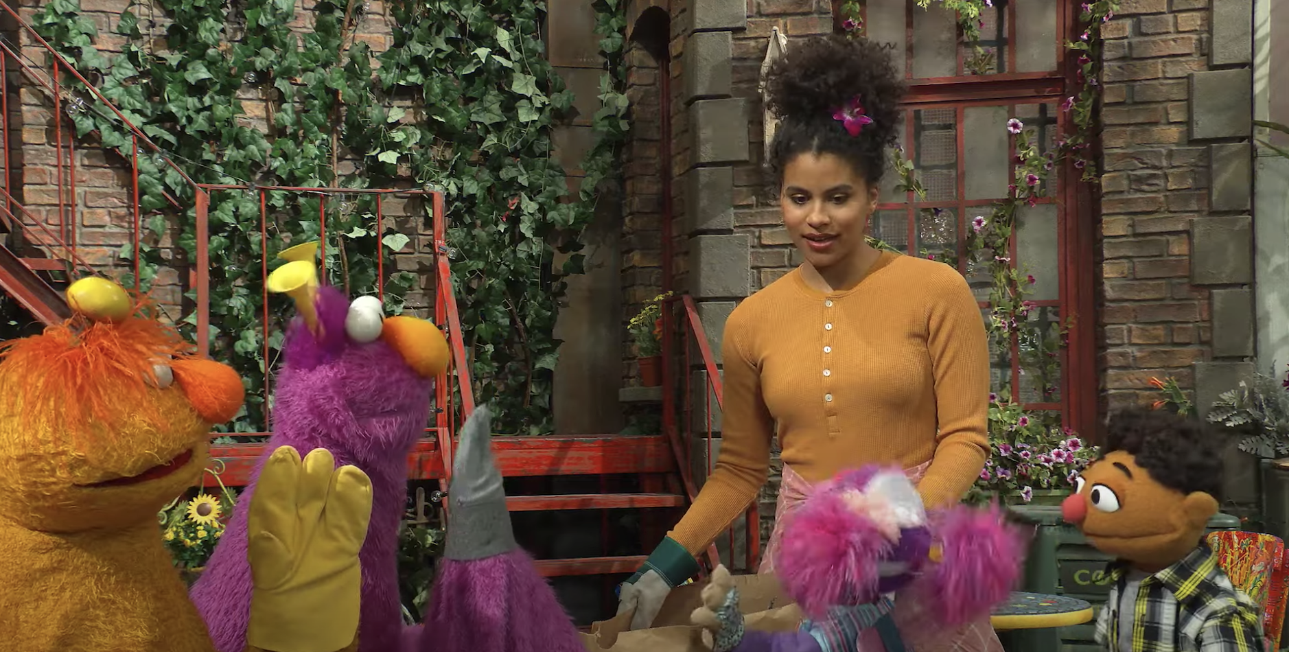Zazie Beetz surrounded by Sesame Street puppets.