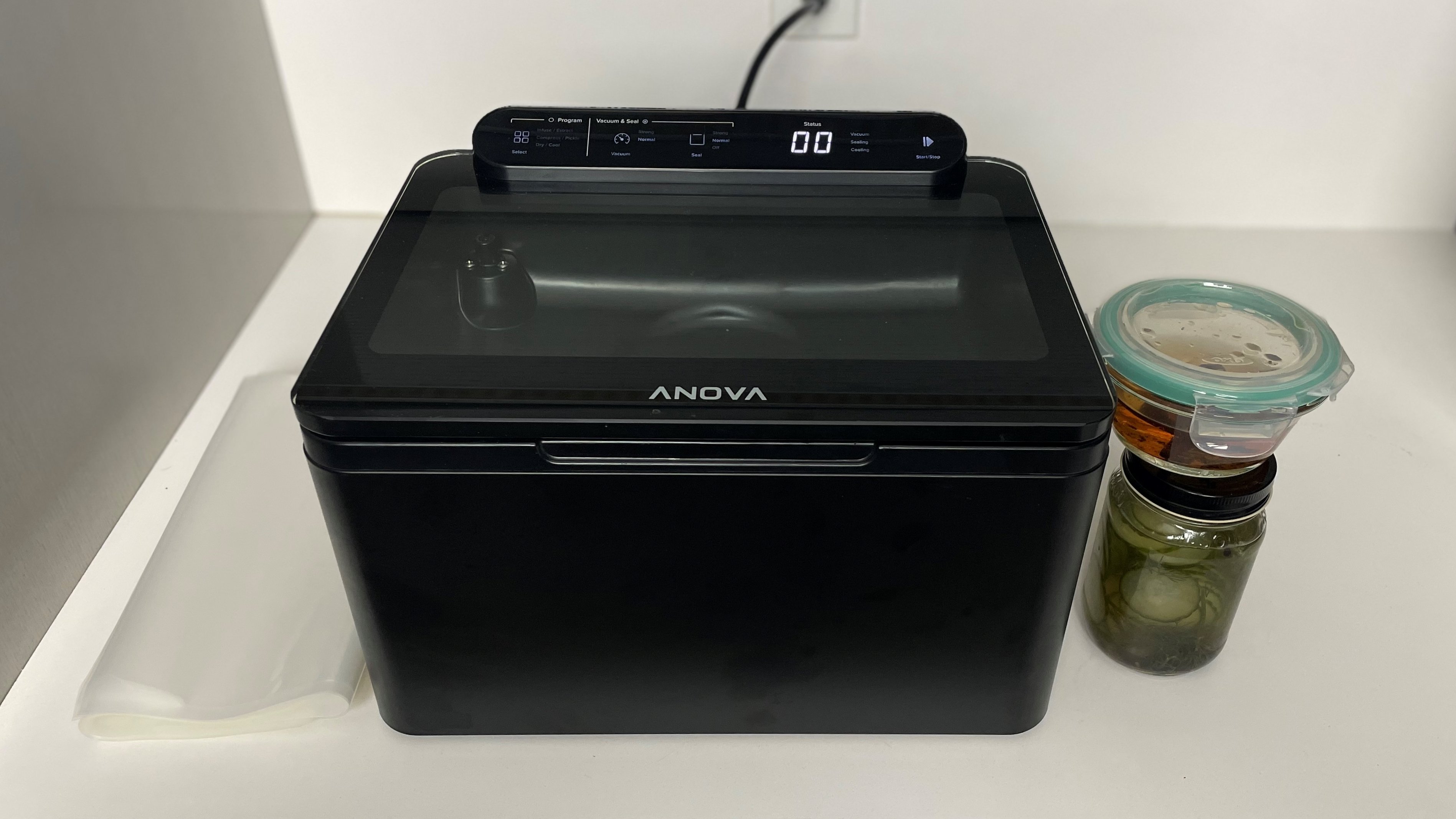 large vacuum sealer on kitchen counter with jars and sealing bags