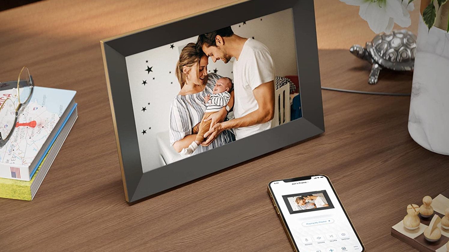 Photo frame showing of two people holding baby and white remote on table beside it