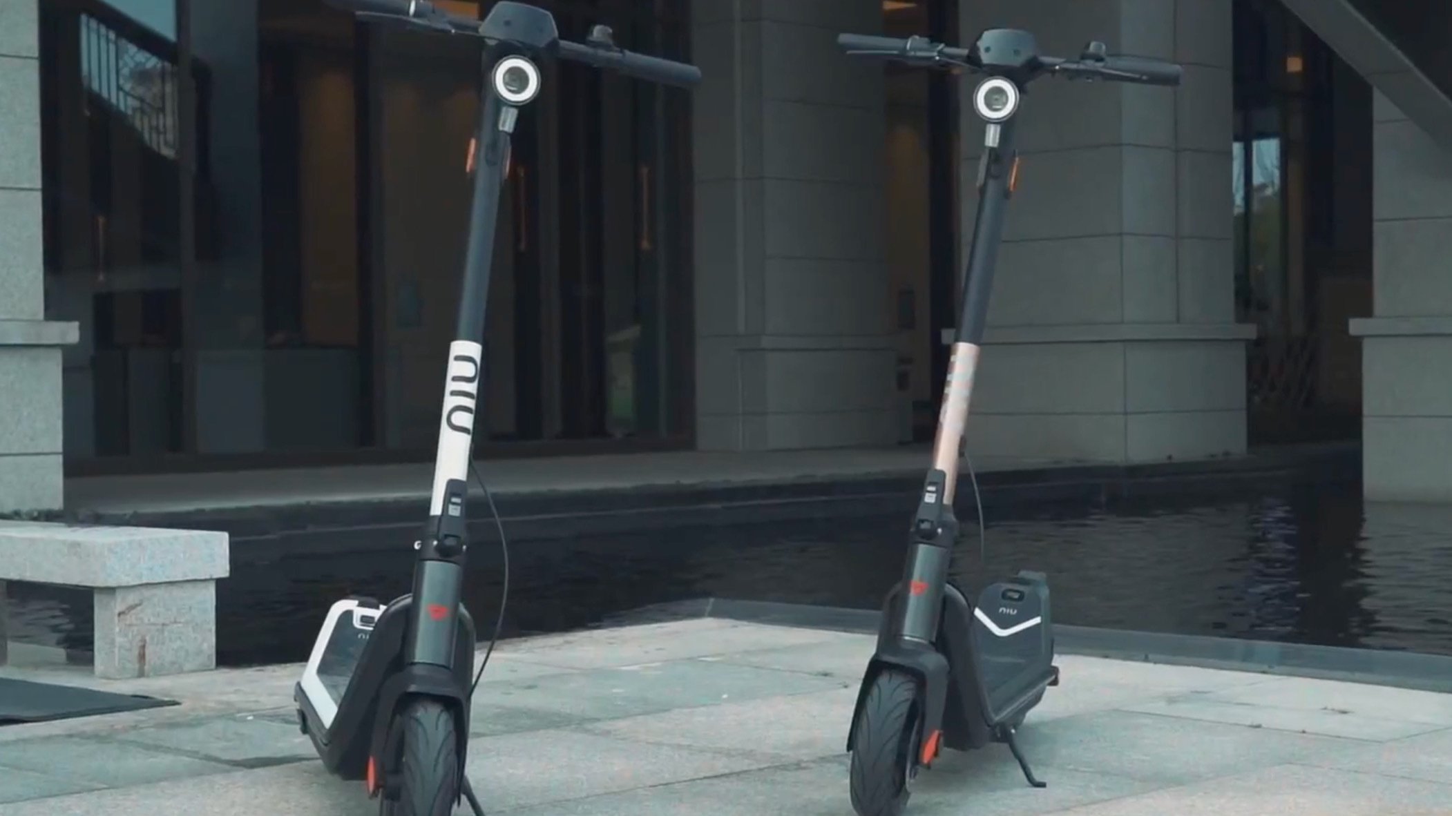 Two electric scooters side by side on pavement