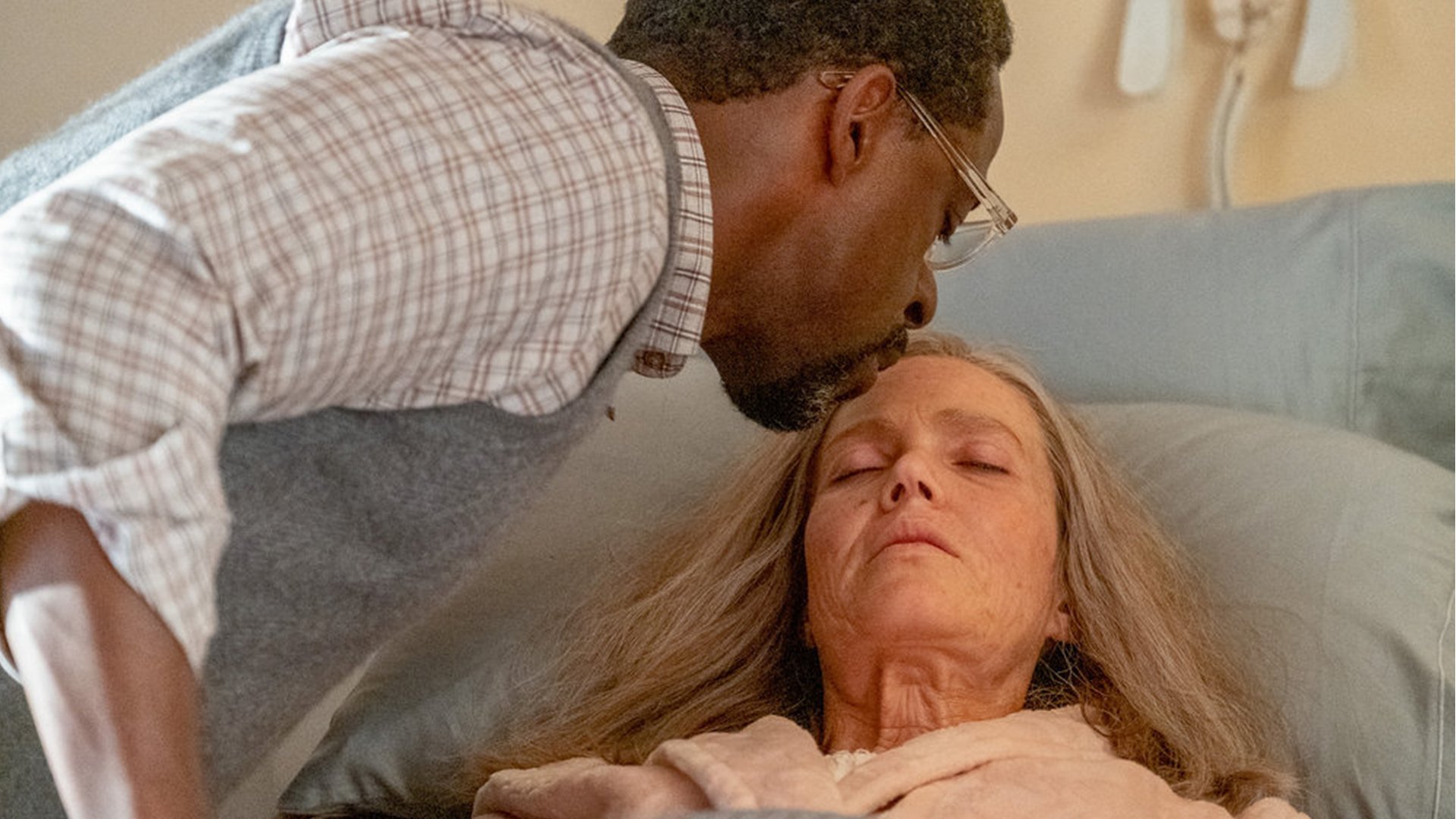 A man (Sterling K. Brown as Randall) kissing the forehead of a woman (Mandy Moore as Rebecca) who's in bed.
