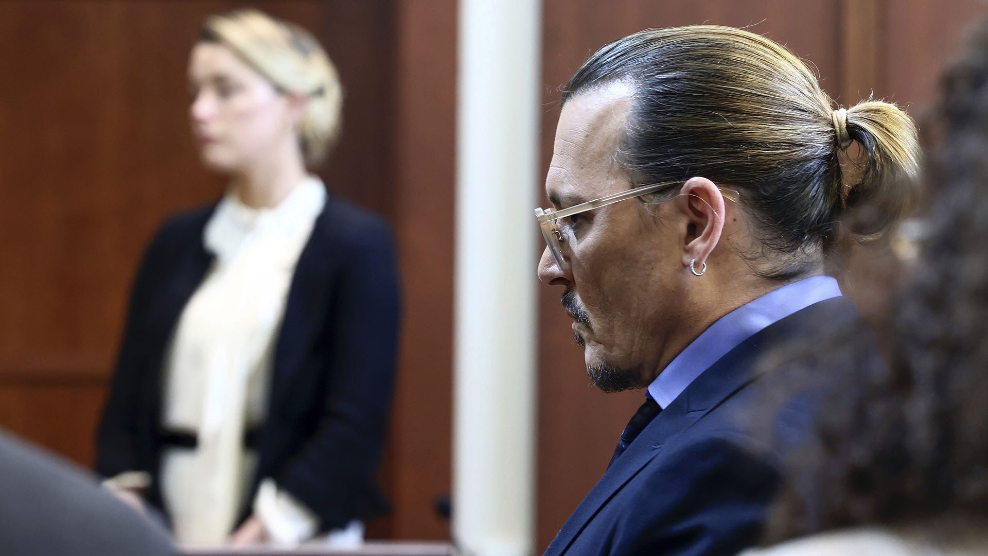 Johnny Depp with Amber Heard in the background in the courtroom.