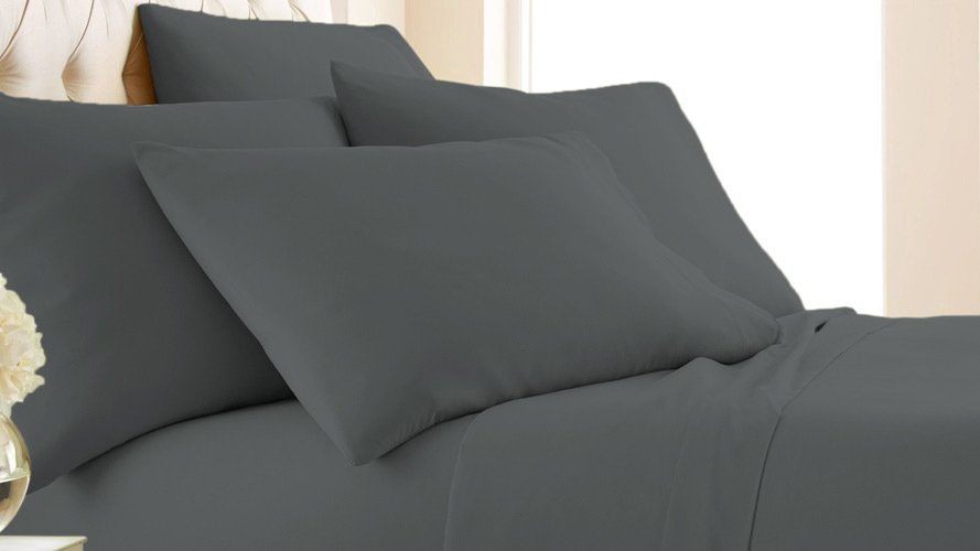 Grey bed with four pillows