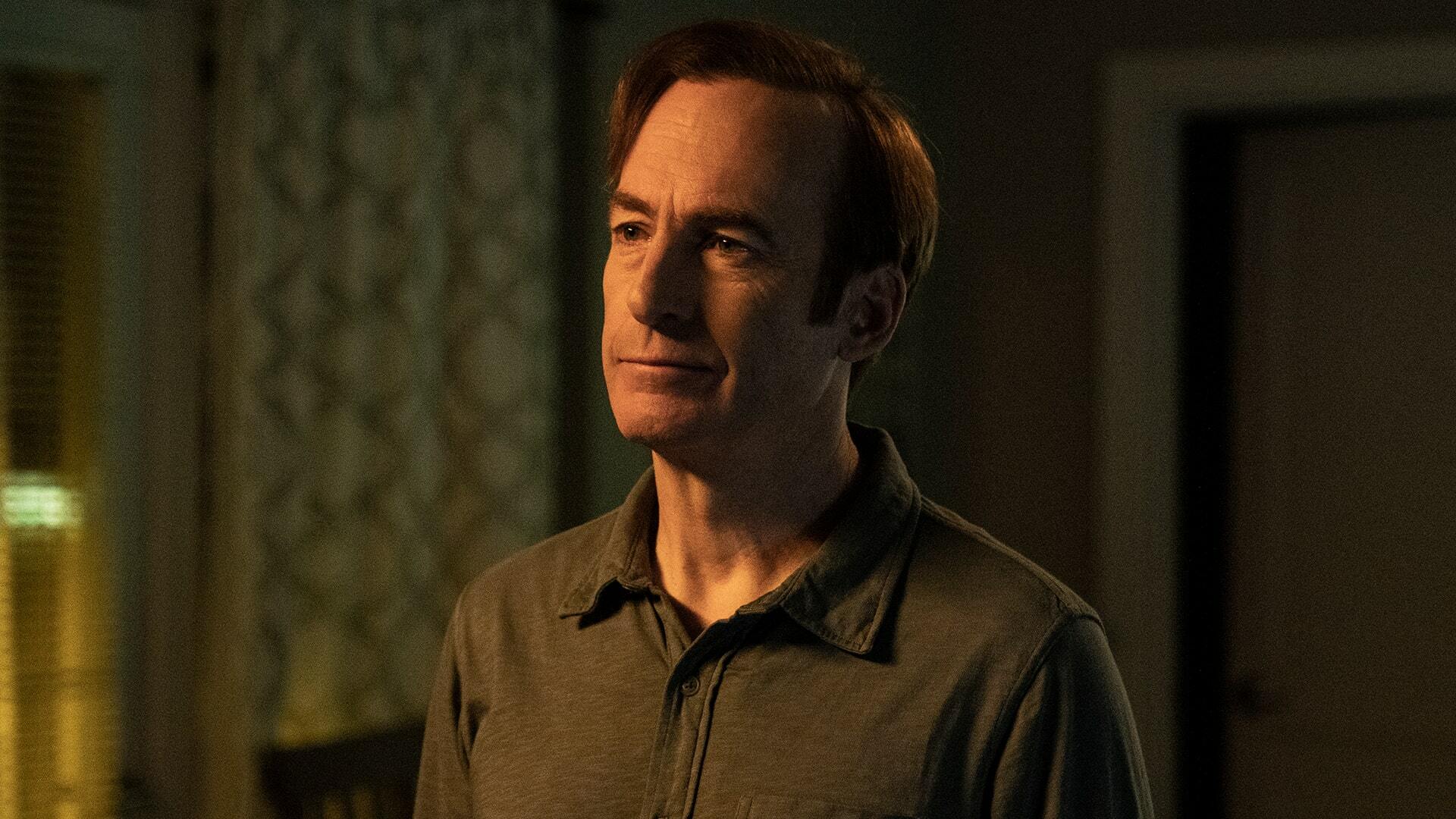 A man (Bob Odenkirk as Jimmy McGill) standing in a dimly lit living room.