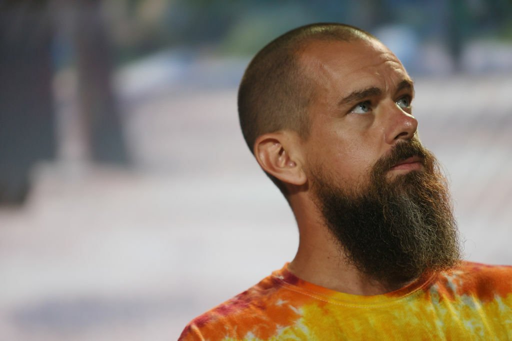 Image of Jack Dorsey with a beard wearing a tie-dye shirt at a bitcoin conference