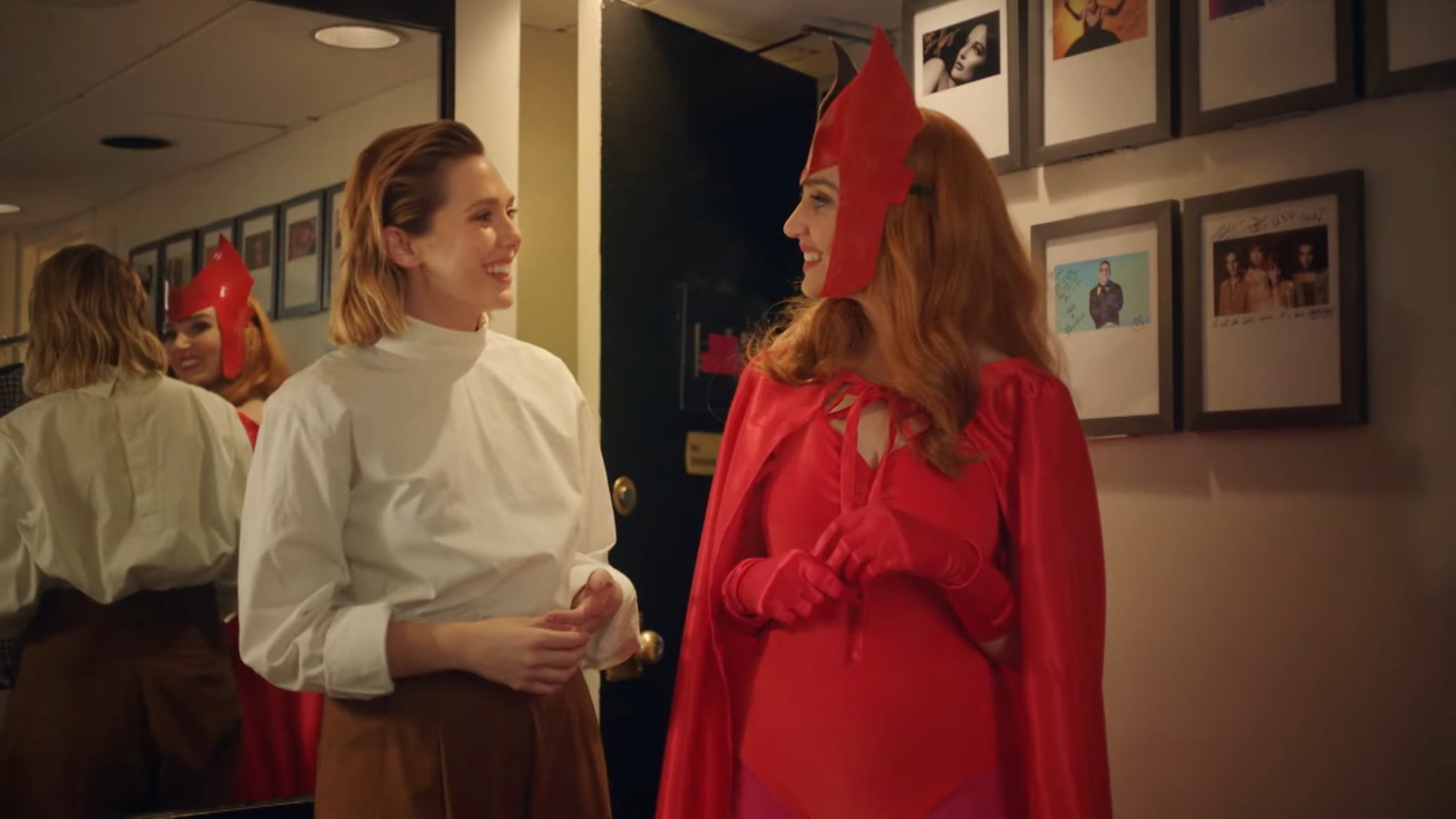 Elizabeth Olsen, dressed in regular clothes, and 'SNL' cast member Chloe Fineman, dressed in a Scarlet Witch costume, stare at each other, smiling.