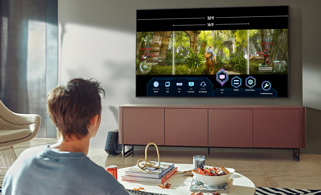 Samsung Q80A 4K TV in living room with man playing generic video game on it.