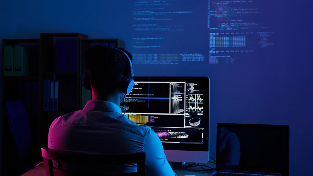 Person coding in dark room