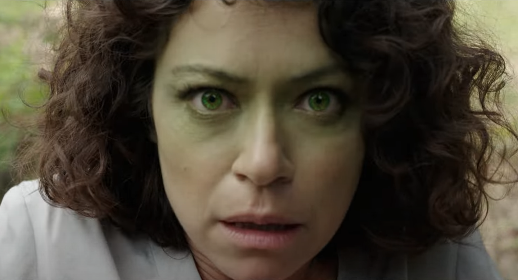 Tatiana Maslany as She-Hulk during a moment of transformation, with her face turning green.