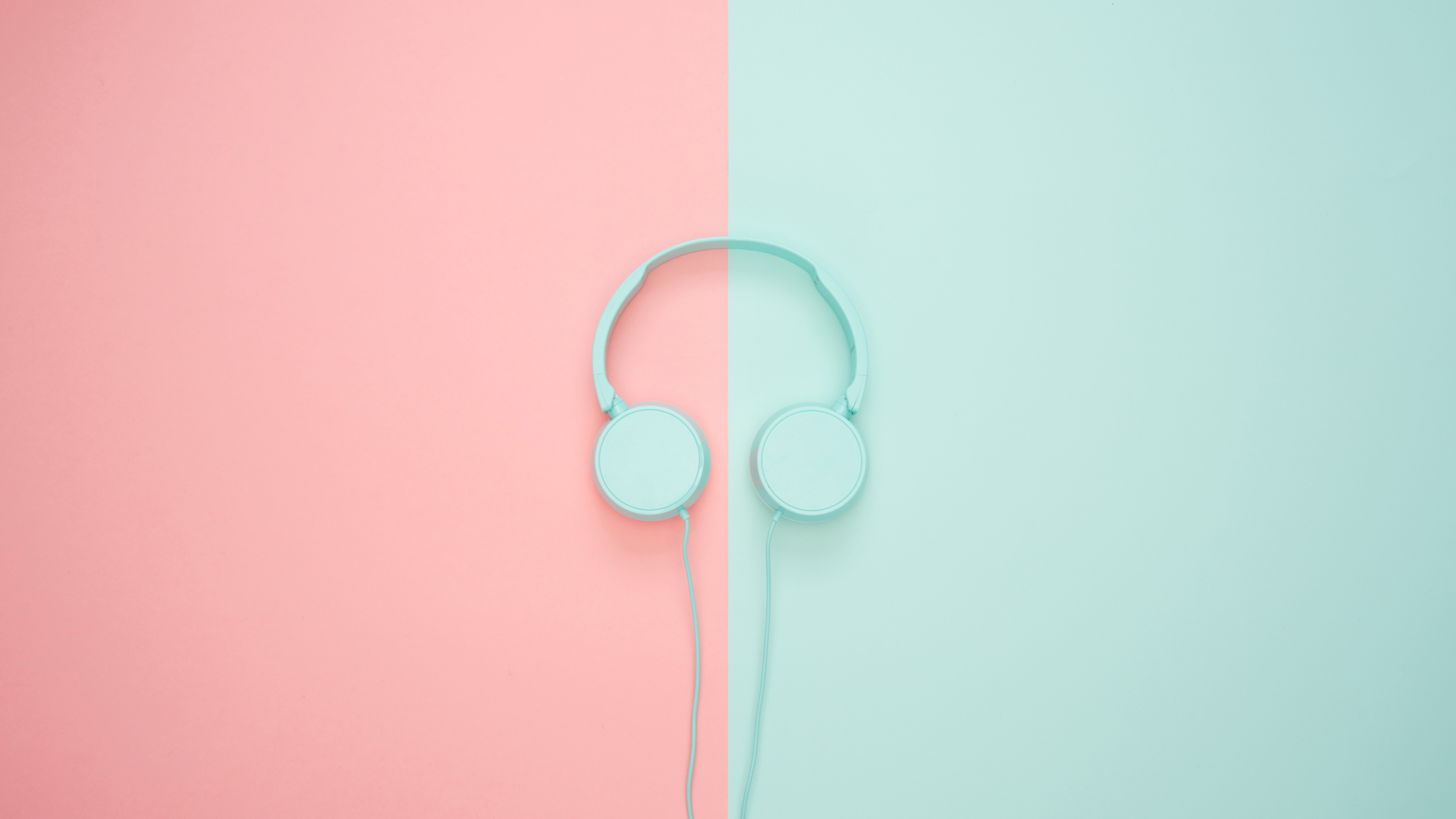 A pair of green headphones on a green and pink background