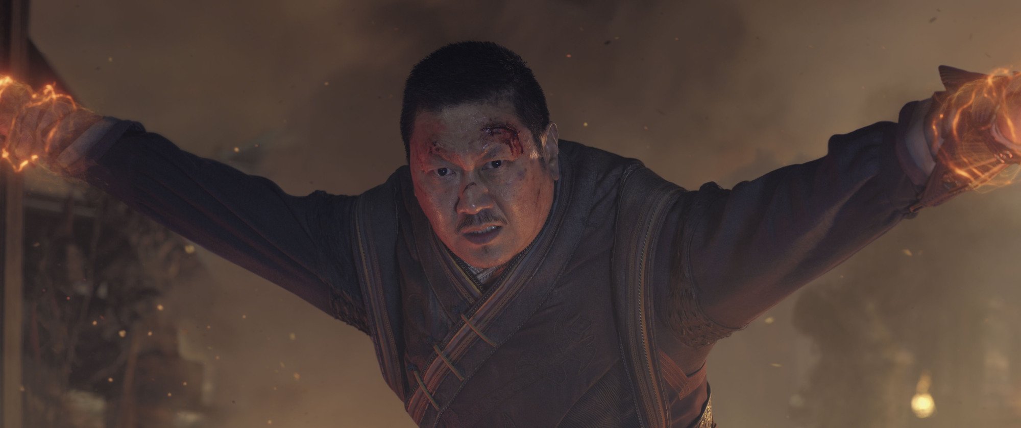 The Marvel Cinematic Universe character Wong is held by magical restraints, his face bloodied.