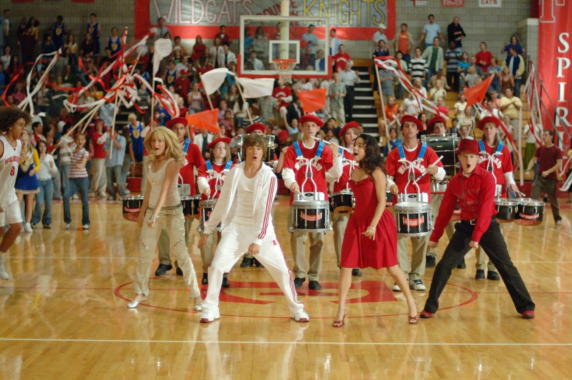 A group of teenagers performing choreography in a high school gym.