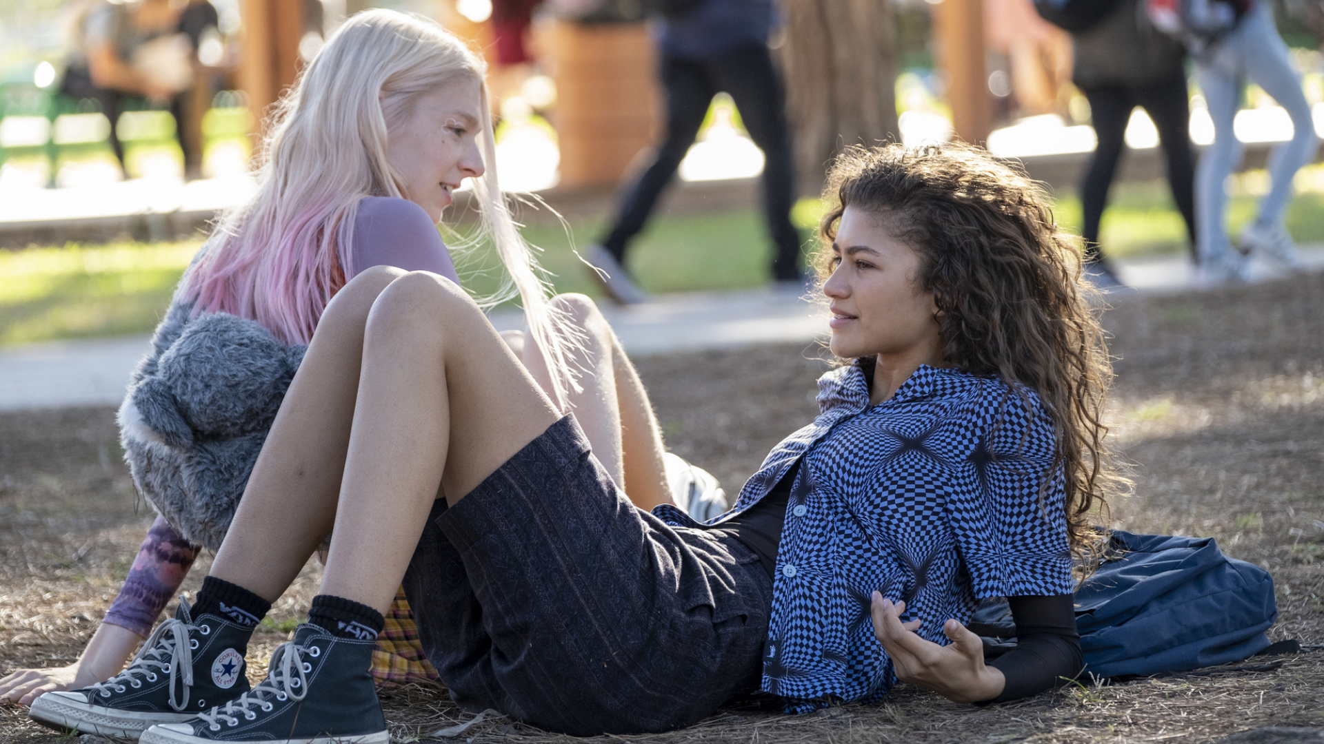 Two teen girls hang out in a park.