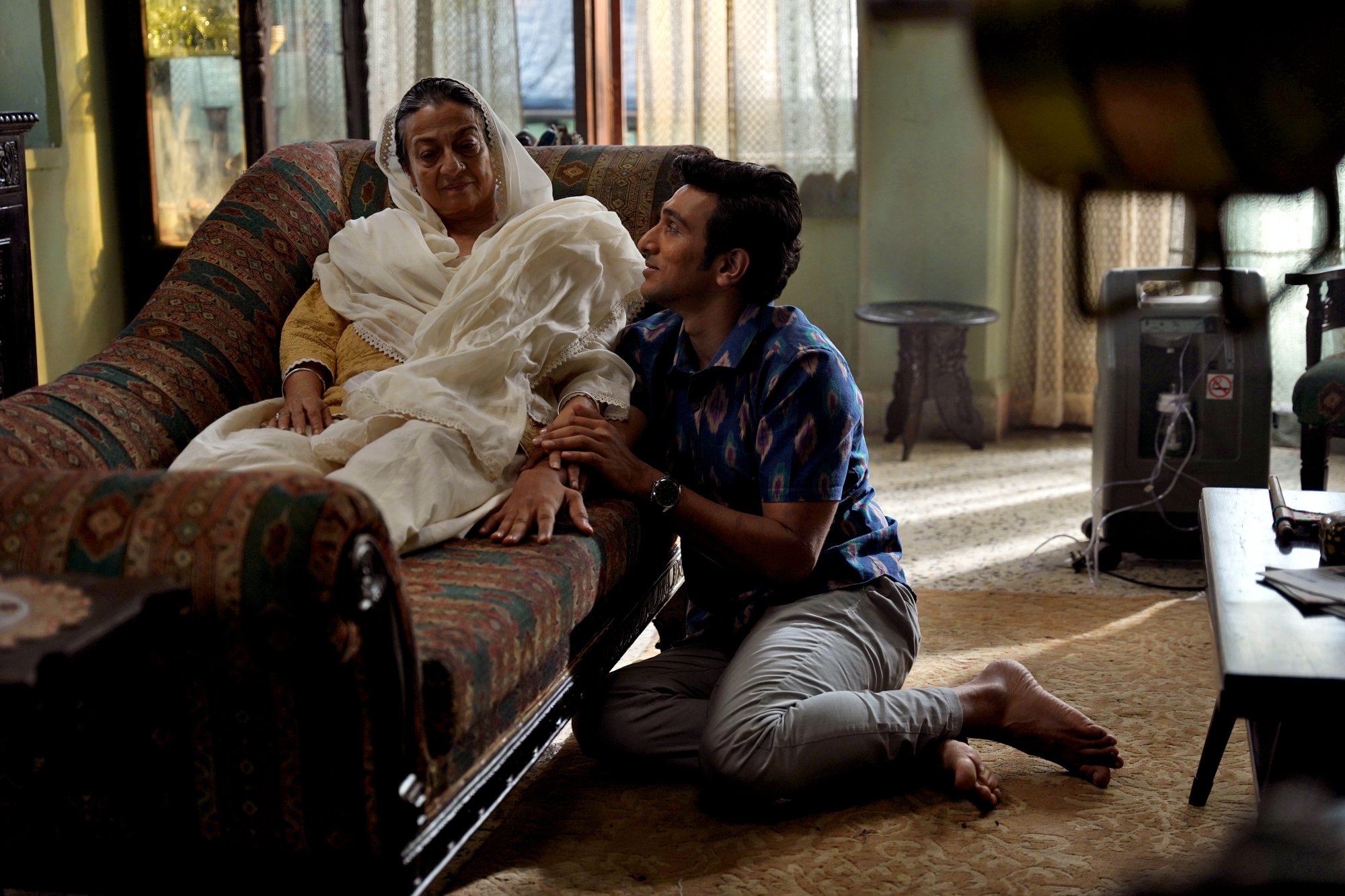 Actors Pratik Gandhi and Tanuja in a still from 'Modern Love Mumbai', with Gandhi perching on the floor by Tanuja's feet.