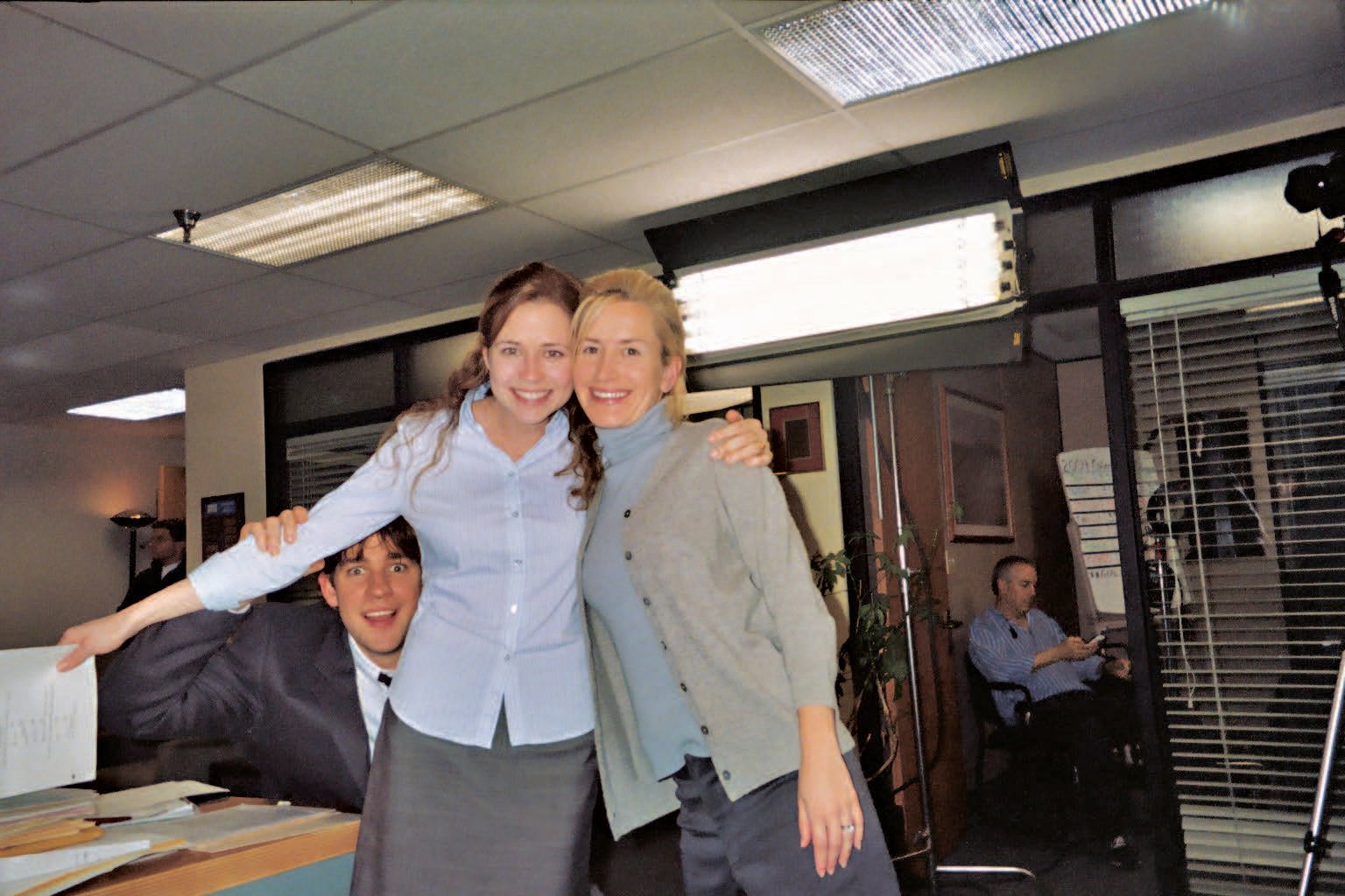 Three cast members of "The Office" standing on set.