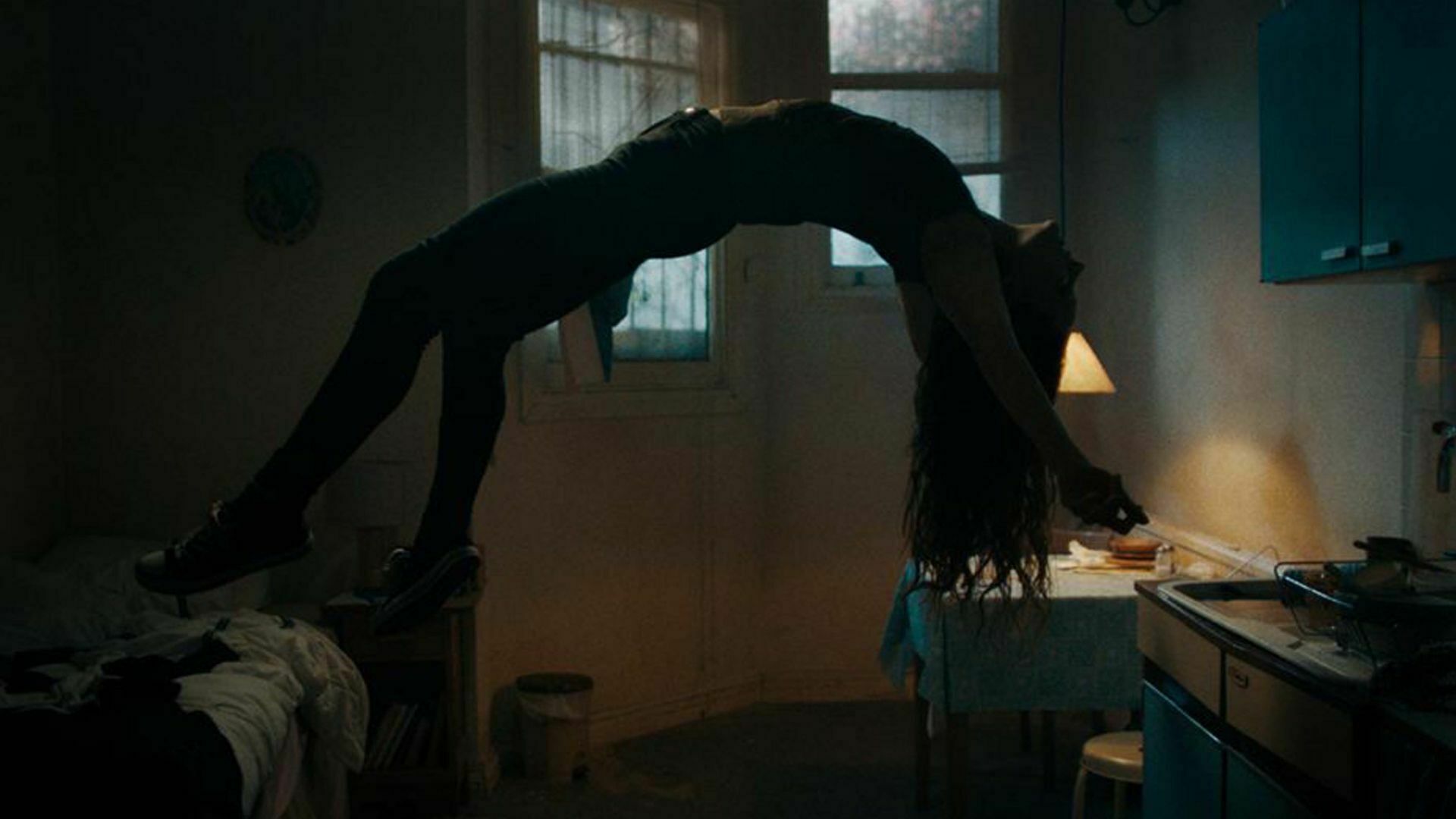 A woman floating over her bed in a throes of demonic posession