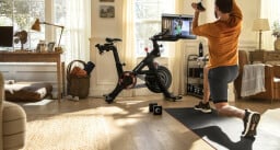 Man working out next to a peloton bike