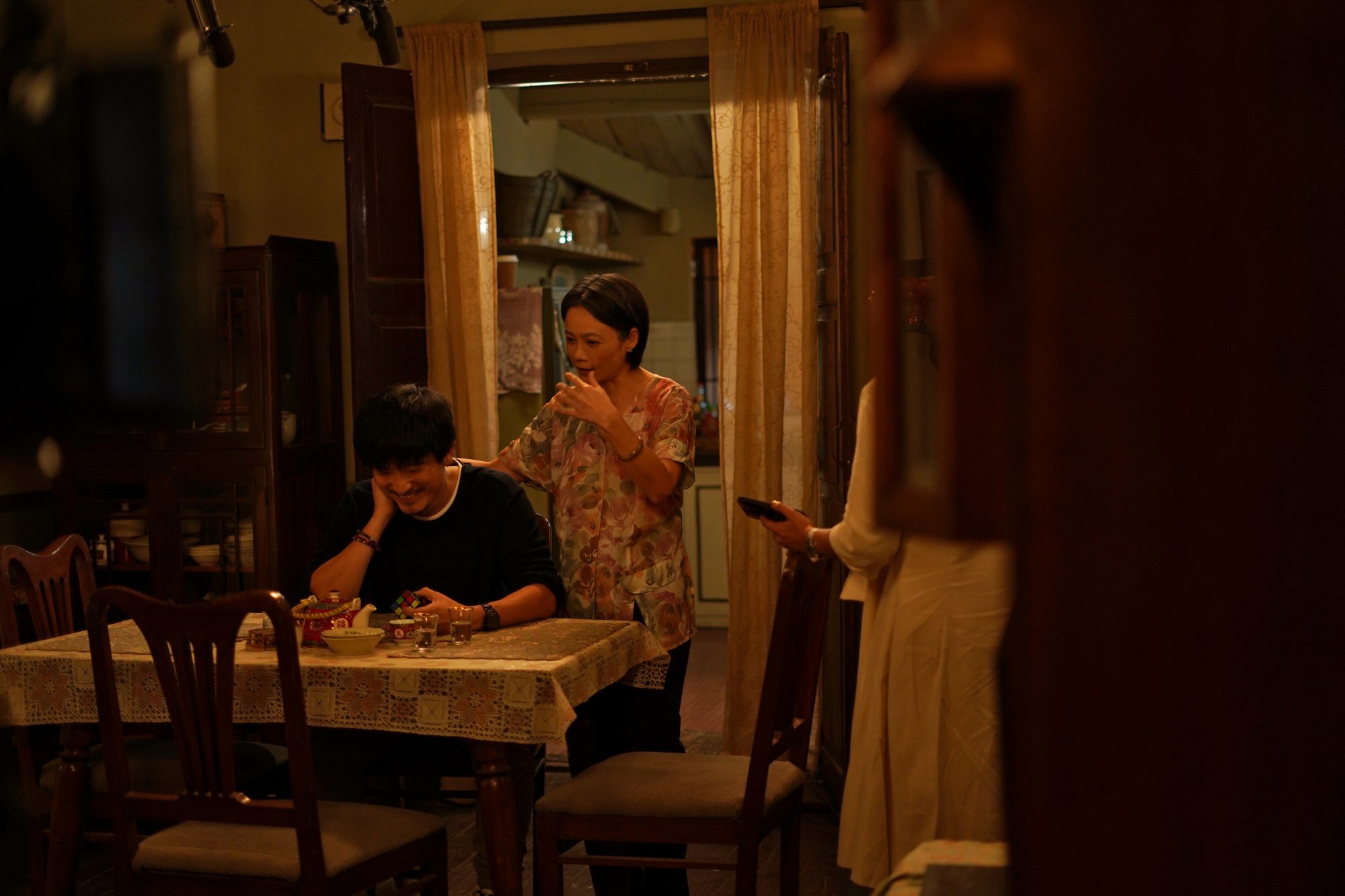 A still of Yann Yann Yeo and Meiyang Chang in "Modern Love Mumbai", sitting at the dining table of their apartment.