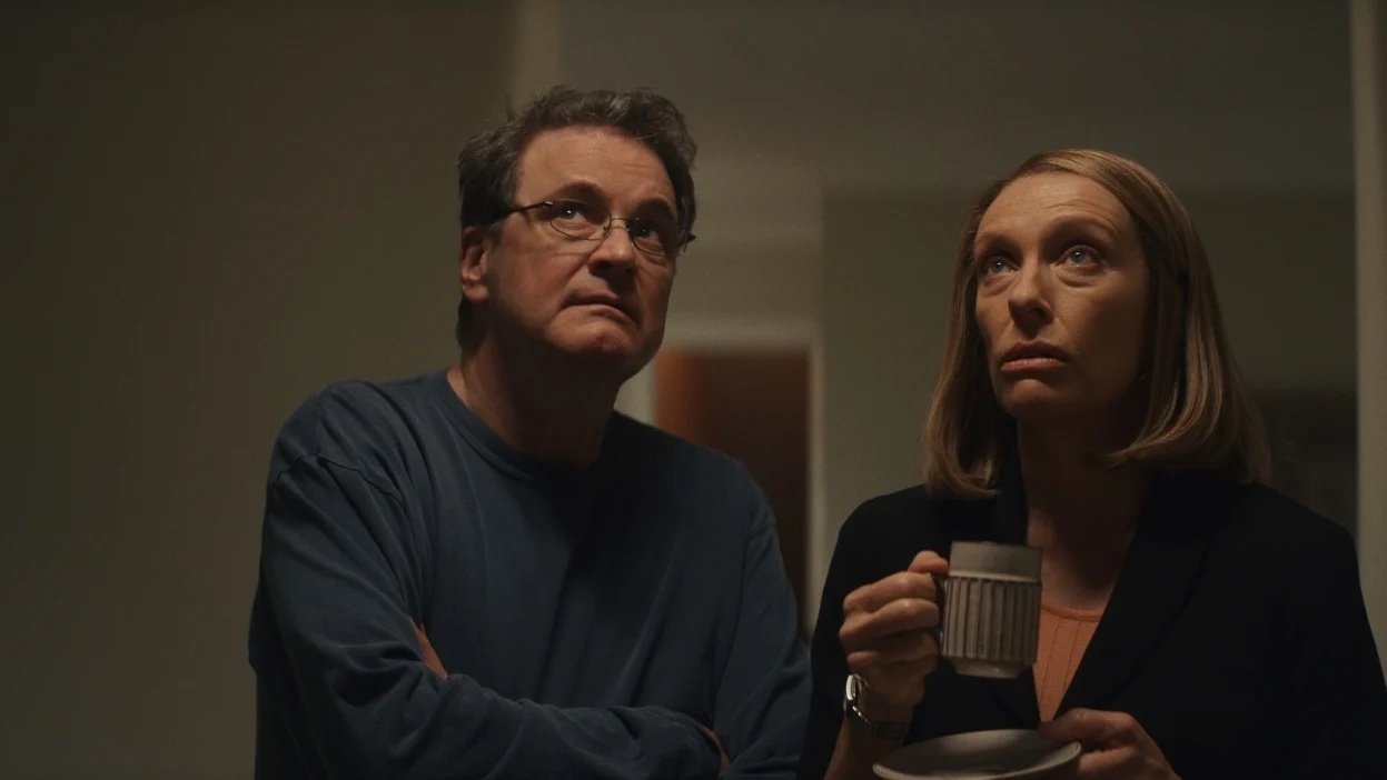 A man and a woman holding a coffee cup stare upwards.